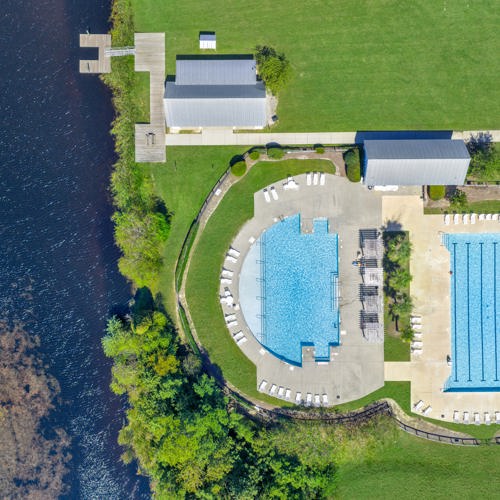 Ariel view of two pools and pavilion with access to lake dock